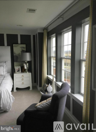A bedroom with a bed, nightstand, and chair.