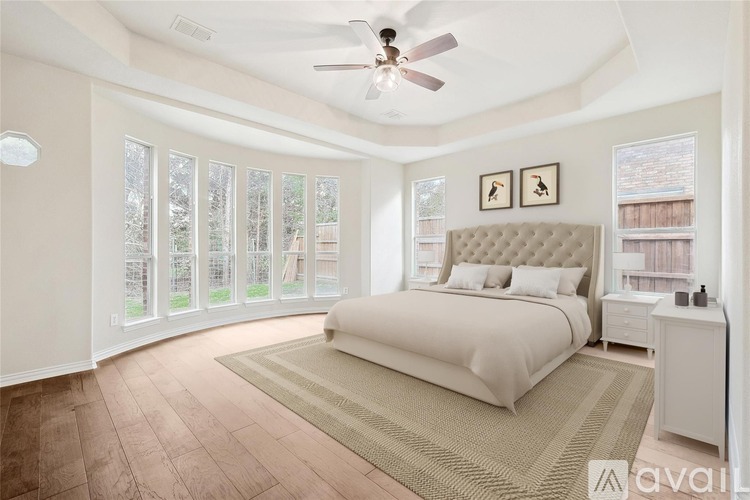 A bedroom with a large bed and a ceiling fan.