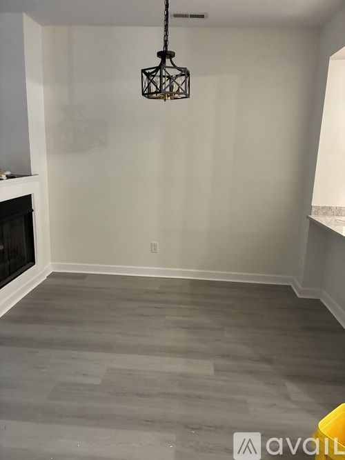 A room with a fireplace and a hanging light fixture.