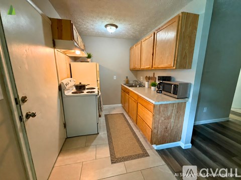 A kitchen with a white refrigerator and wooden cabinets.