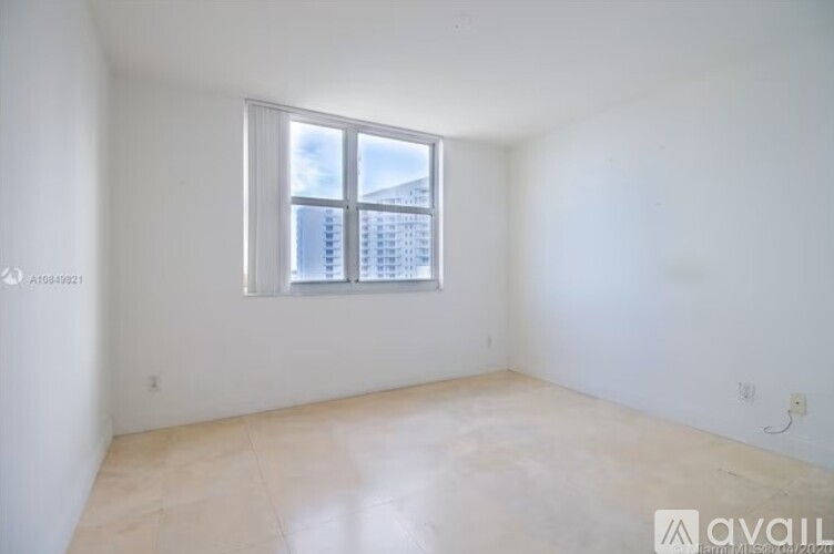 A room with a window and a view of a building outside.