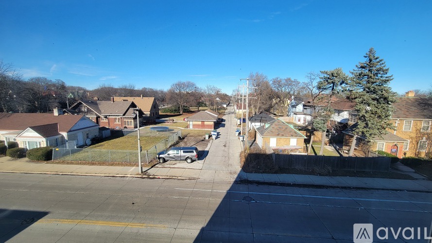 A street view of a residential area with houses and cars.