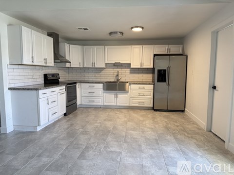 A kitchen with white cabinets and a tile backsplash.