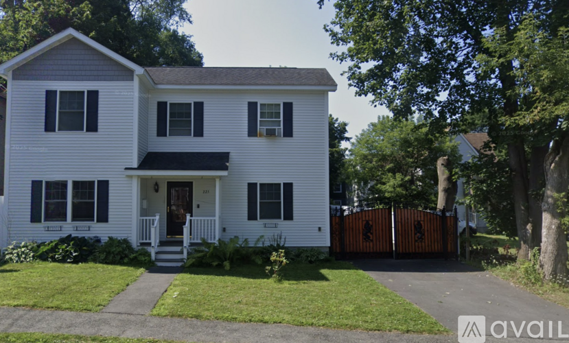 A two-story house with a white exterior and a brown fence.