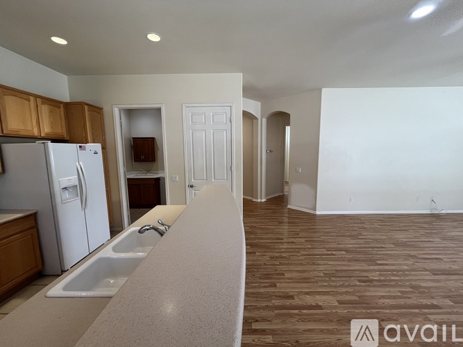 A kitchen with a white refrigerator and wooden cabinets.
