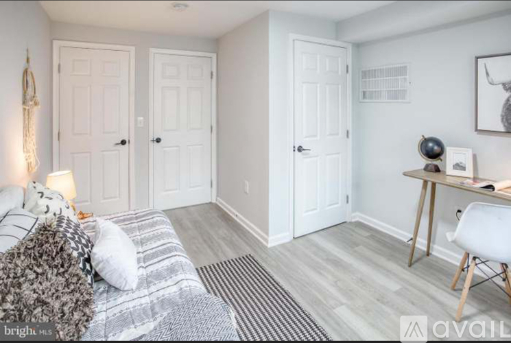 A bedroom with a bed, a desk, and a chair.