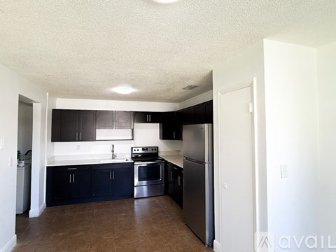 A kitchen with black cabinets and stainless steel appliances.