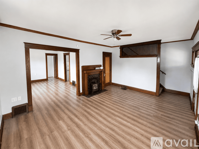 A living room with wood flooring and a ceiling fan.