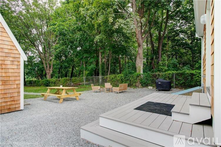 A backyard with a picnic table, a hot tub, and a deck.