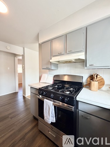 A modern kitchen with a stove top oven and wooden floors.