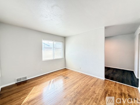 A room with wooden flooring and a window.