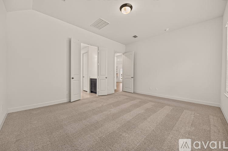 A spacious room with a striped carpet and a ceiling light.