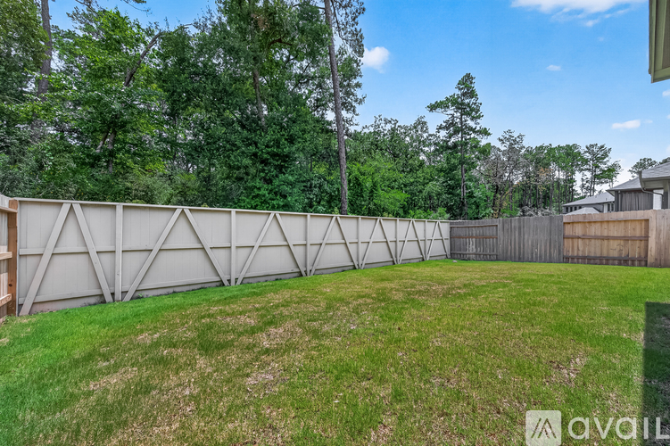A backyard with a fence and trees in the background.