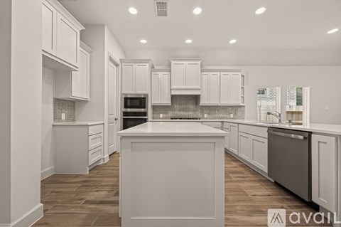 A modern kitchen with white cabinets and a central island.