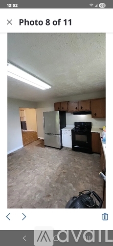 A kitchen with a refrigerator, oven, and cabinets.