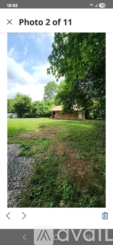 A house is situated in a grassy area with trees around it.