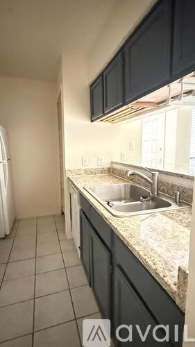 A kitchen with a sink and a refrigerator.