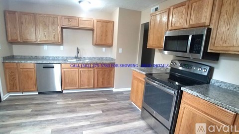 A kitchen with wooden cabinets and a black fridge.