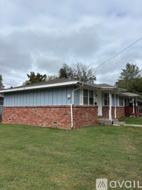A house with a grey roof and a brick wall.