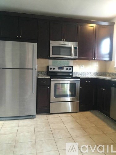 A kitchen with a stainless steel refrigerator, microwave, oven, and dishwasher.