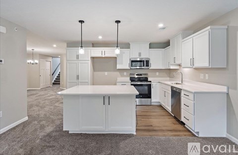 A spacious kitchen with white cabinets and appliances.
