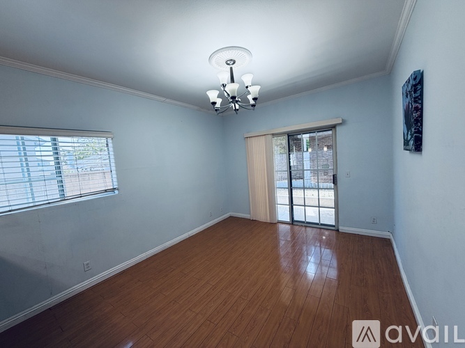 A room with wooden floors and a sliding glass door.