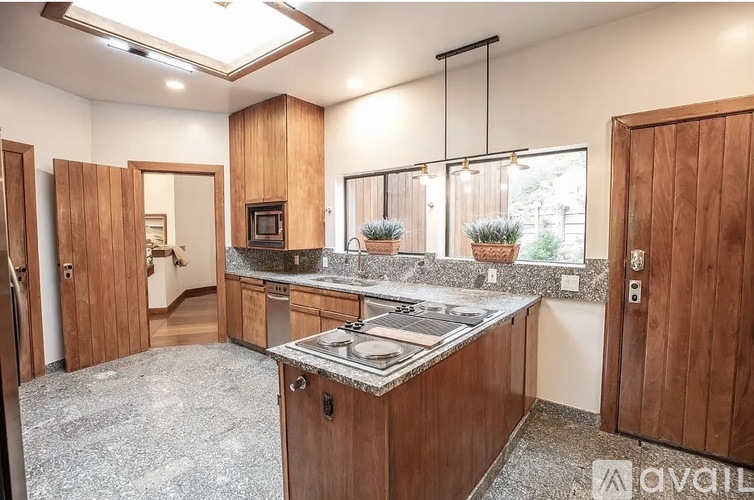 A kitchen with wooden cabinets and a granite countertop.