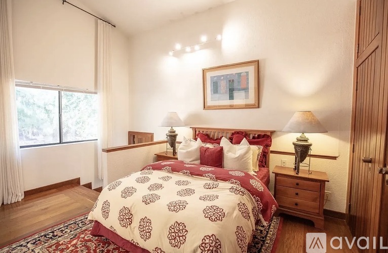 A bedroom with a large bed and a painting on the wall.
