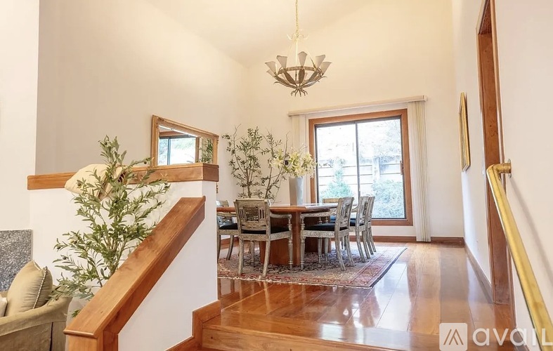 A dining room with a wooden table and chairs.