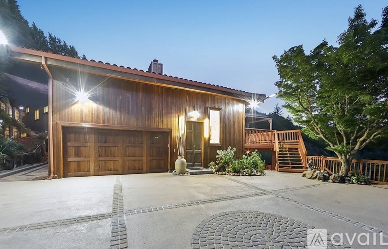 A house with a wooden exterior and a large driveway.
