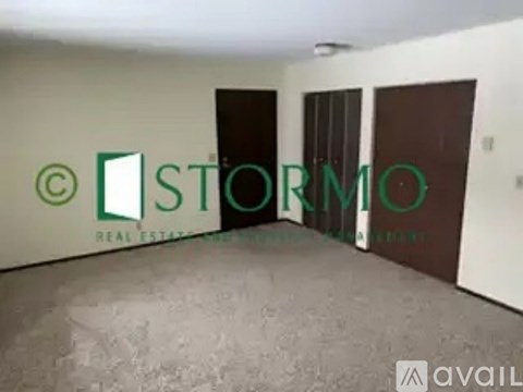 A room with a sign that says "STORMO REAL ESTATE" on the wall.