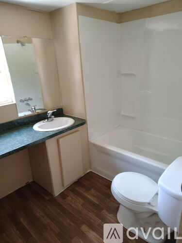 A bathroom with a toilet, sink, and bathtub.
