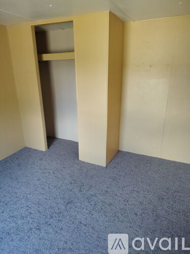 A room with a carpeted floor and a wall with a cut out.