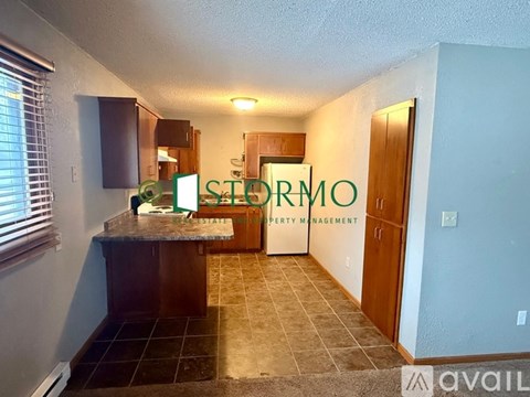 A kitchen area with a counter and cabinets is shown in a property management office.