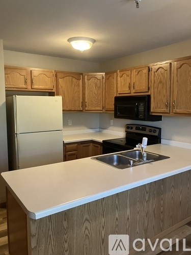 A kitchen with wooden cabinets and a white countertop.