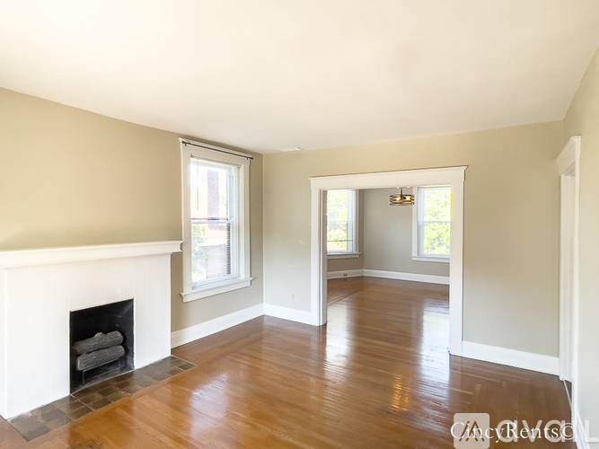 A living room with a fireplace and wood floors.