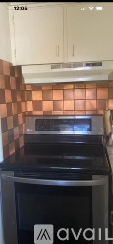 A kitchen with a black oven and white cabinets.