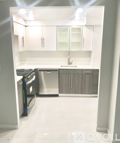 A kitchen with white cabinets and a stainless steel dishwasher.