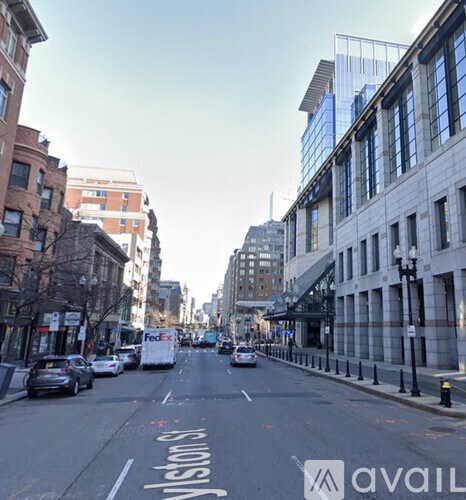A city street with cars and buildings on either side.