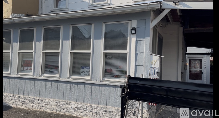 A white house with a sign that says "ZELLOW" on the window.