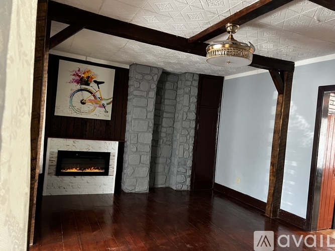 A room with a fireplace and a painting of a bicycle on the wall.
