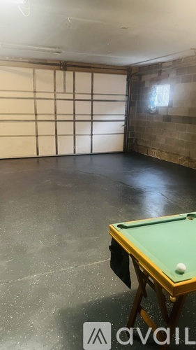 A pool table with a green cloth and white balls is in the middle of a room with a tatami mat wall.