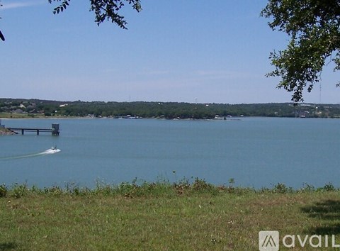 A boat is sailing on a lake with a bridge in the background.