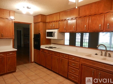 A kitchen with wooden cabinets and a white counter top.