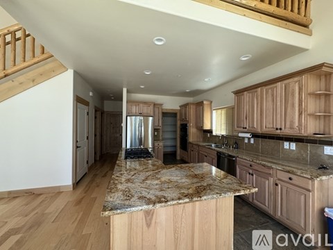 A kitchen with wooden cabinets and a granite countertop.