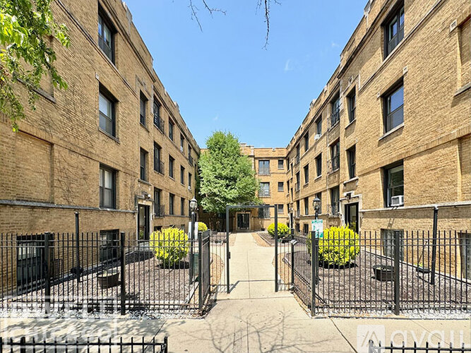 A gated courtyard surrounded by brick buildings.