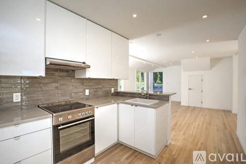 A modern kitchen with white cabinets and a stainless steel oven.