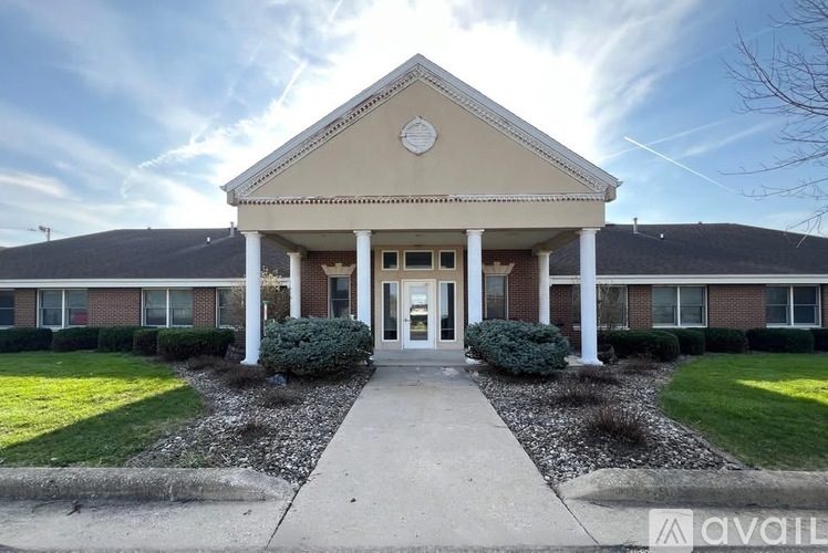 A building with a front porch and a sign that says "available" in the foreground.
