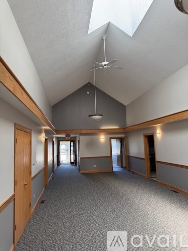 A spacious hallway with a skylight and a fan.