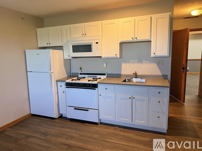 A kitchen with white appliances and cabinets.